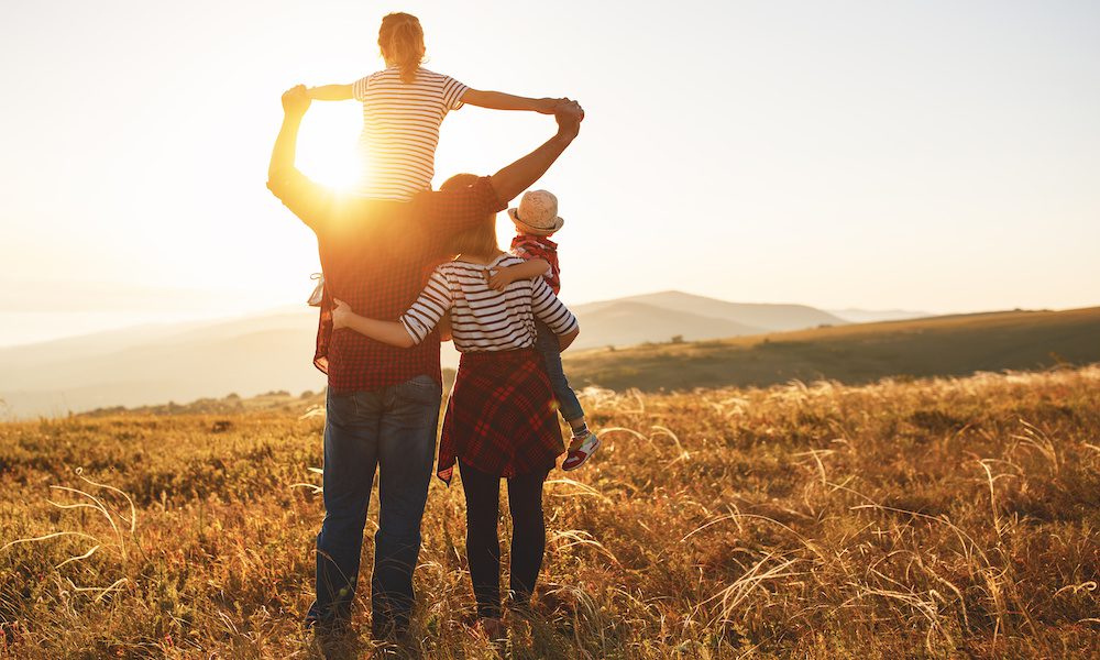 Happy family: mother, father, children son and daughter on sunset